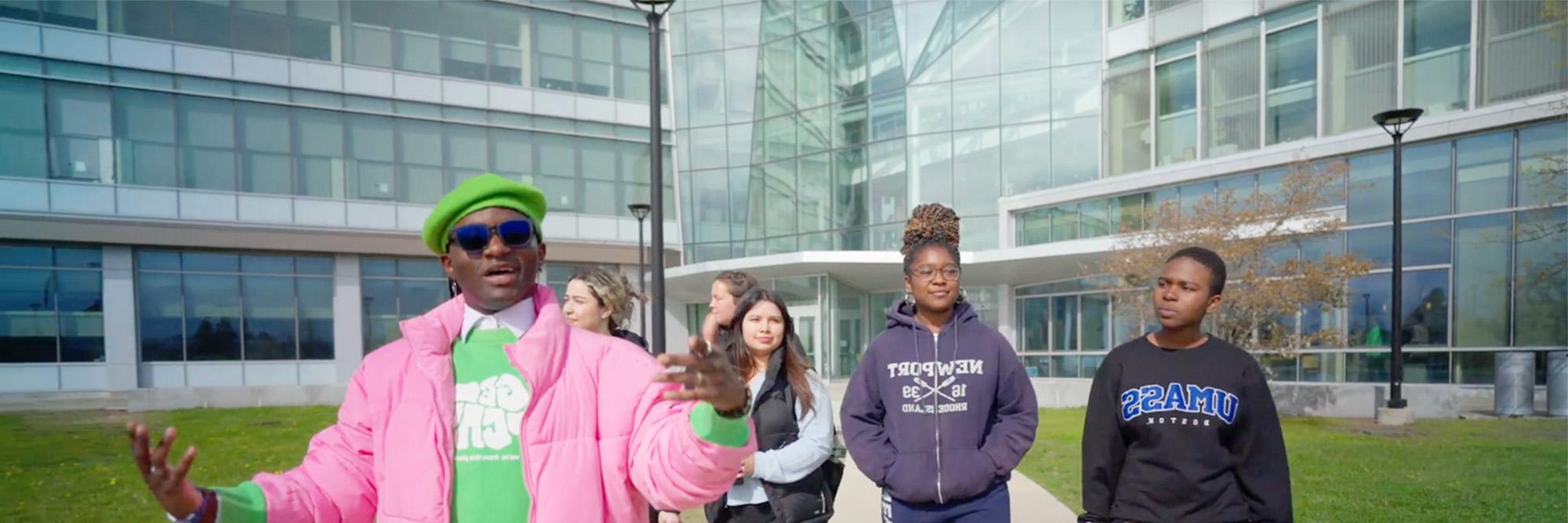 A UMass Boston Beacon Ambassador leads a group on a campus tour